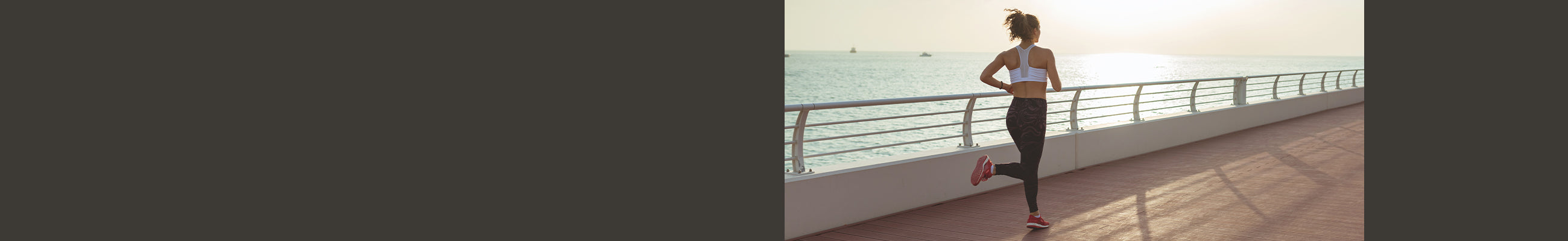 Female runner on boardwalk by ocean