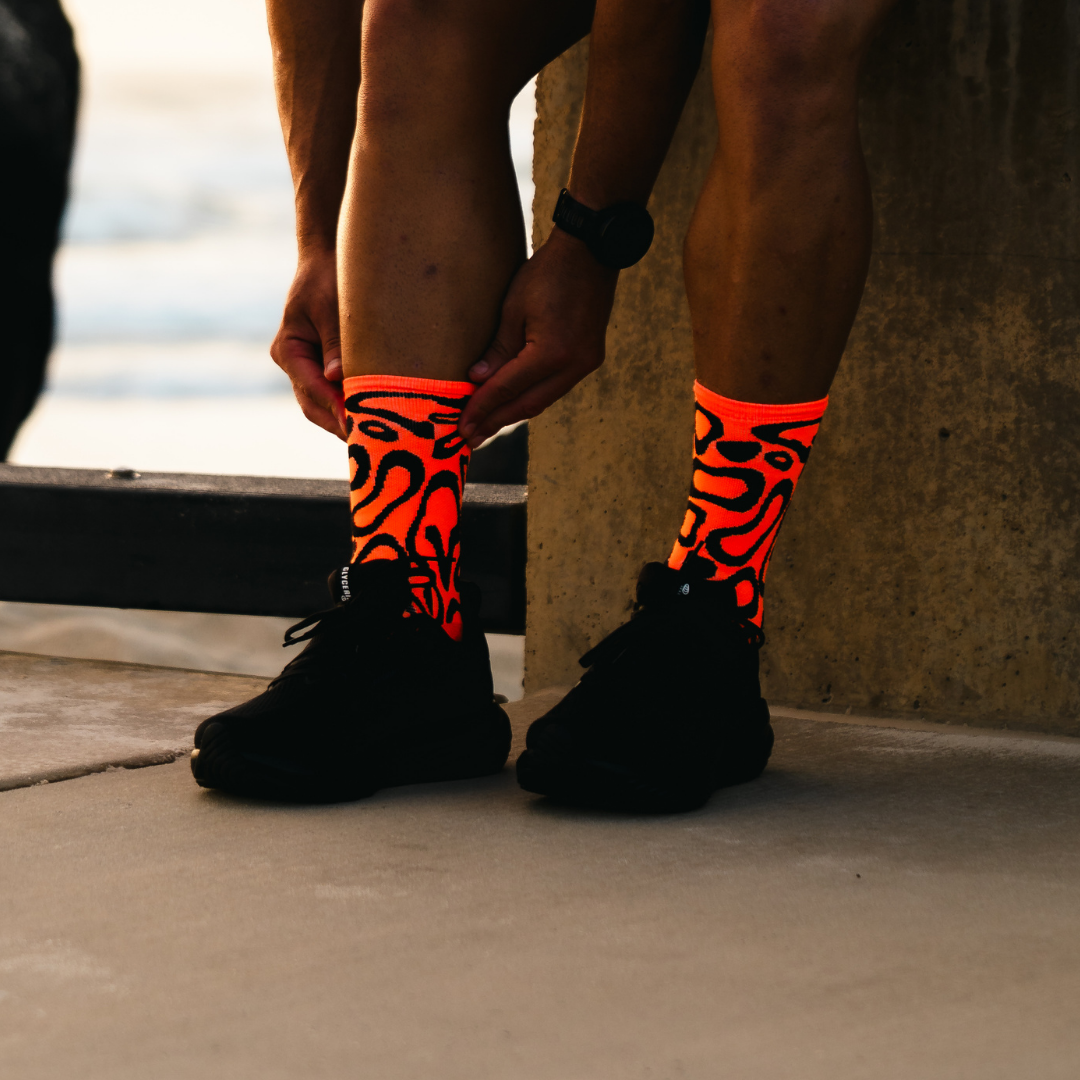 Image of person wearing Lightfeet Performance Scribbles Orange Black Crew Socks 