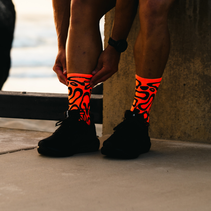 Image of person wearing Lightfeet Performance Scribbles Orange Black Crew Socks 