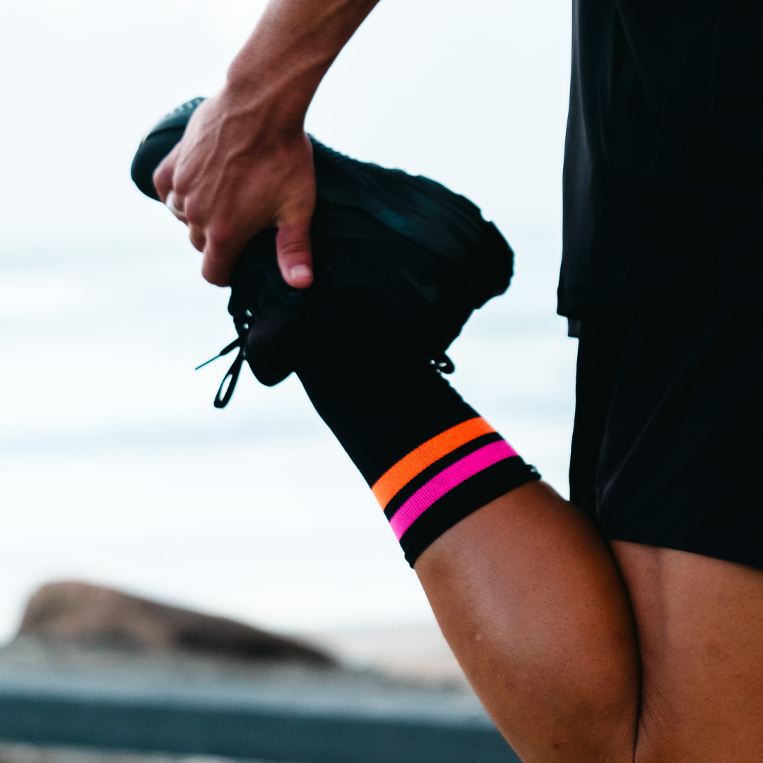 Image of person wearing Lightfeet Performance 2 Stripes Black Pink Orange Crew Socks 