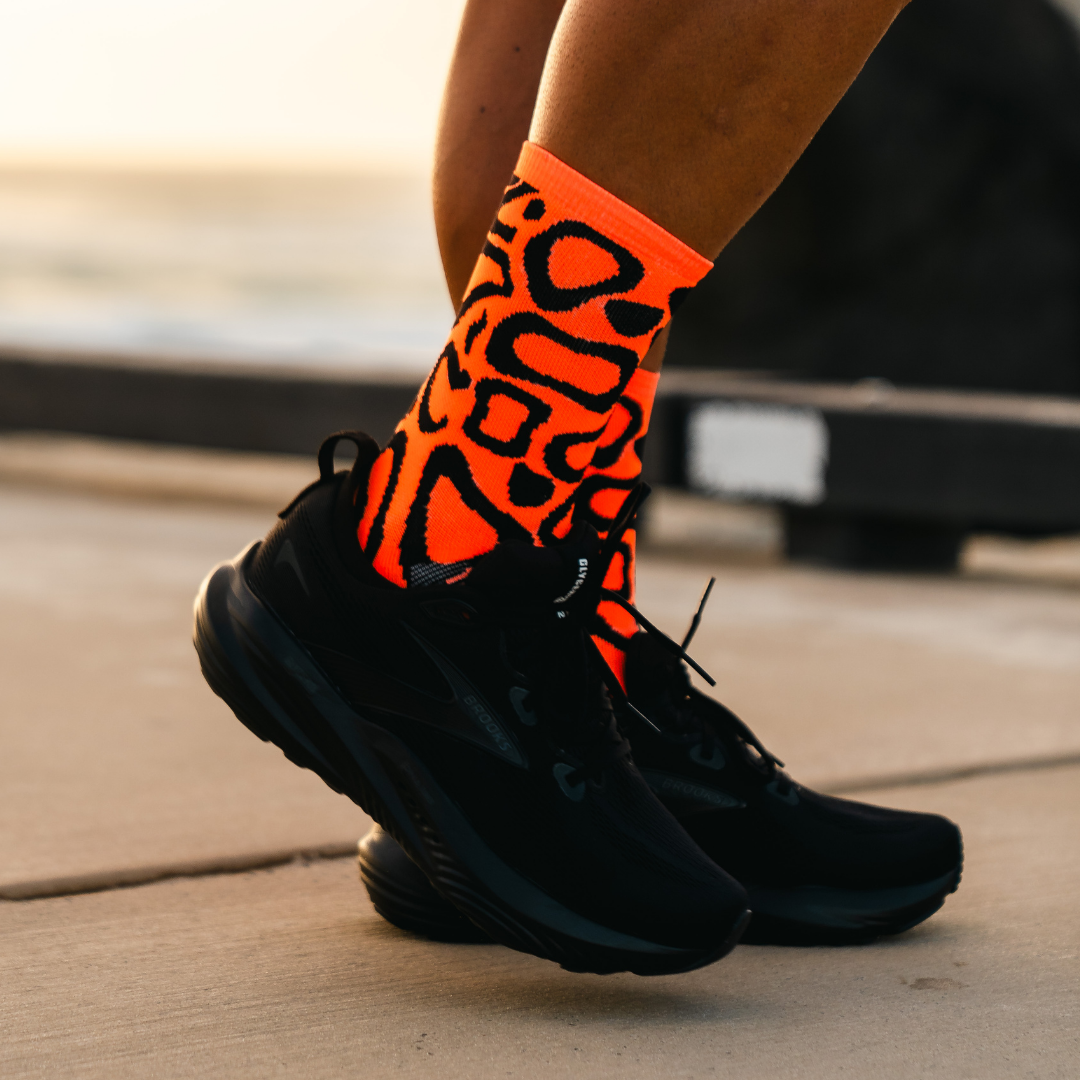 Image of person wearing Lightfeet Performance Scribbles Orange Black Crew Socks 
