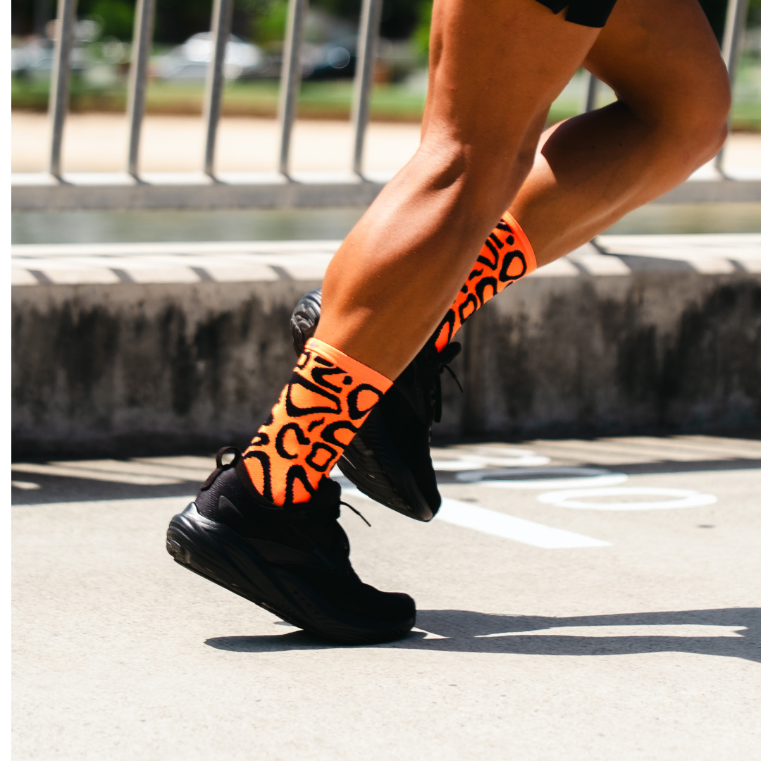 Image of person wearing Lightfeet Performance Scribbles Orange Black Crew Socks 
