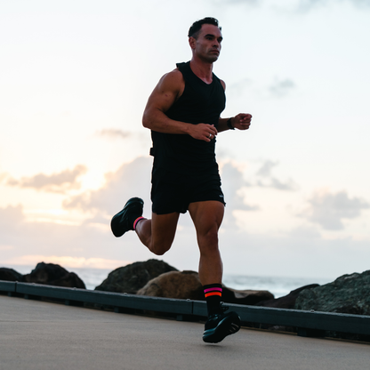 Image of person wearing Lightfeet Performance 2 Stripes Black Pink Orange Crew Socks 
