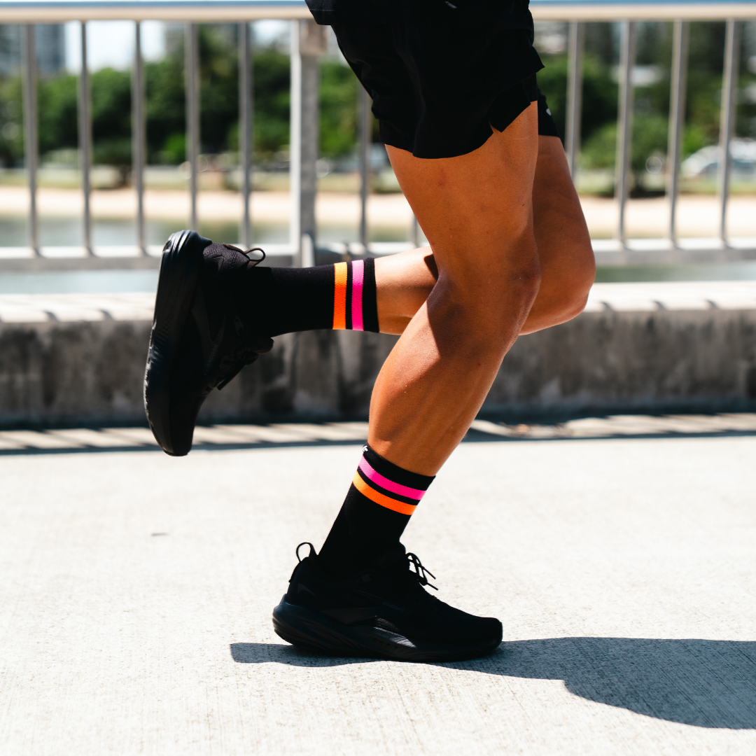 Image of person wearing Lightfeet Performance 2 Stripes Black Pink Orange Crew Socks 