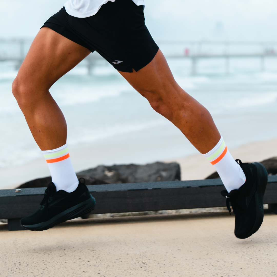 Image of person wearing Lightfeet Performance 2 Stripes White Yellow Orange Crew Socks 