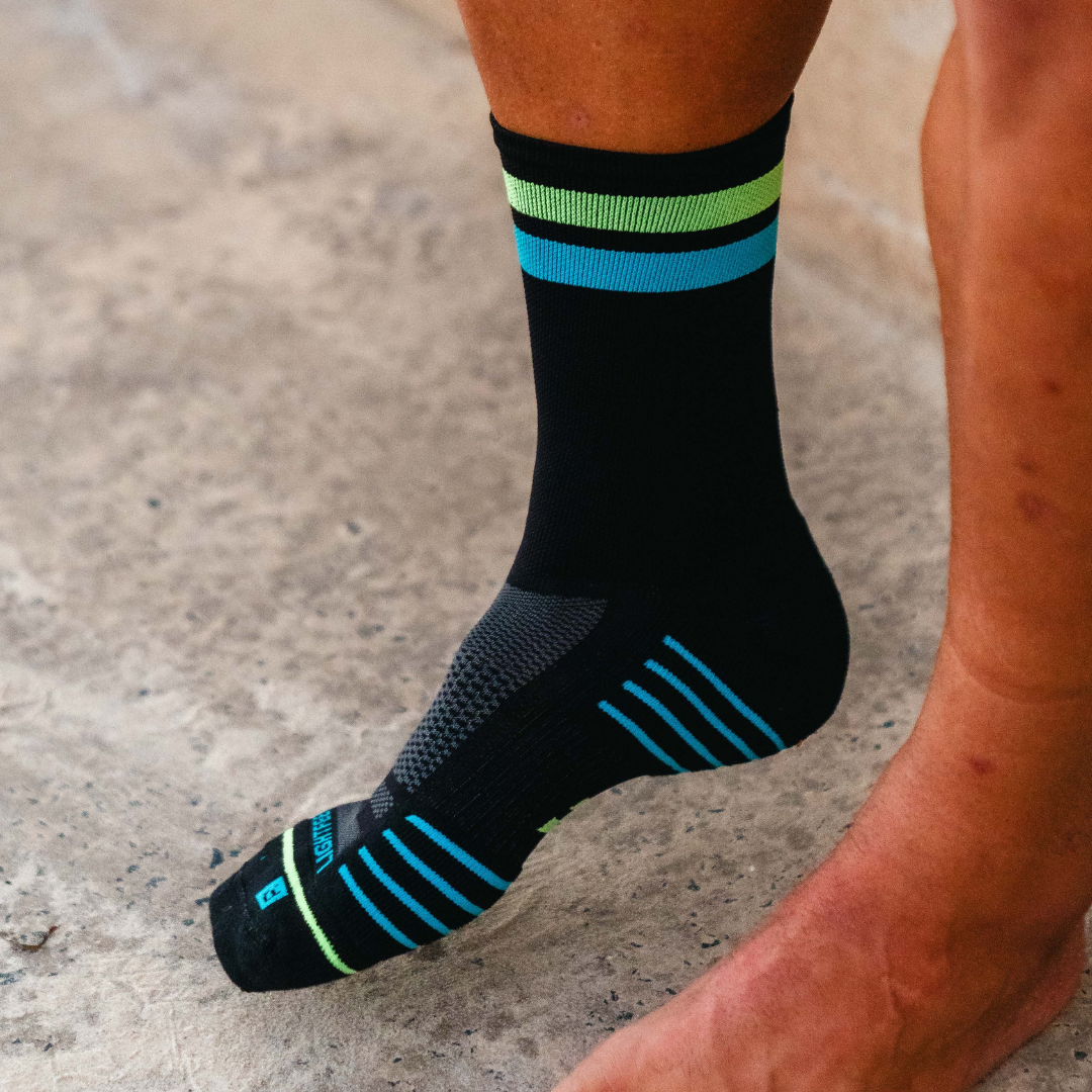 Image of person wearing Lightfeet Performance 2 Stripes Black Yellow Aqua Crew Socks 