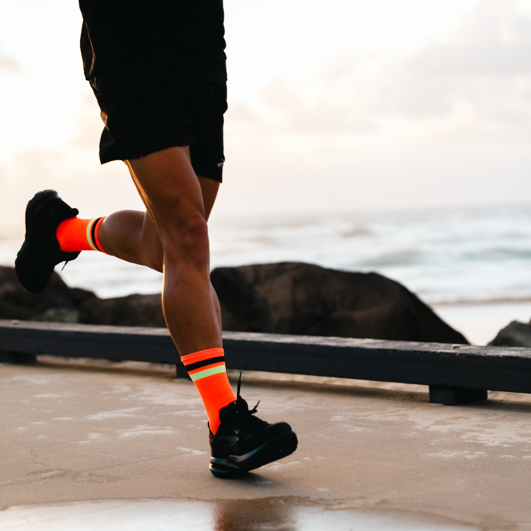 Image of person wearing Lightfeet Performance 2 Stripes Orange Black Yellow Crew Socks 