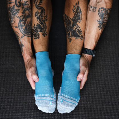 Person wearing Lightfeet Performance Soft Blue Quarter Crew Socks 